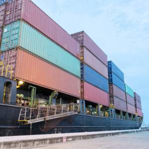 Back view of Red Container truck in ship port Logistics.Transportation industry in port business concept.import,export logistic industrial Transporting Land transport on Port transportation storge